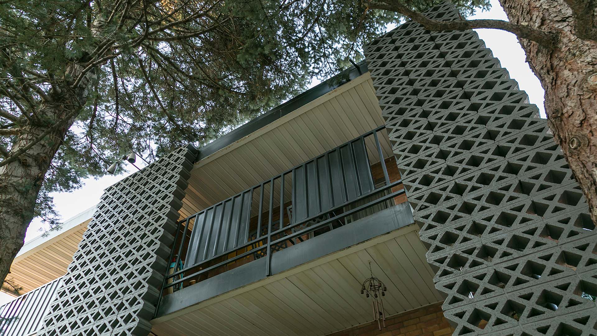 70 Clarkson apartment balconies with decorative cinderblock construction and large trees.