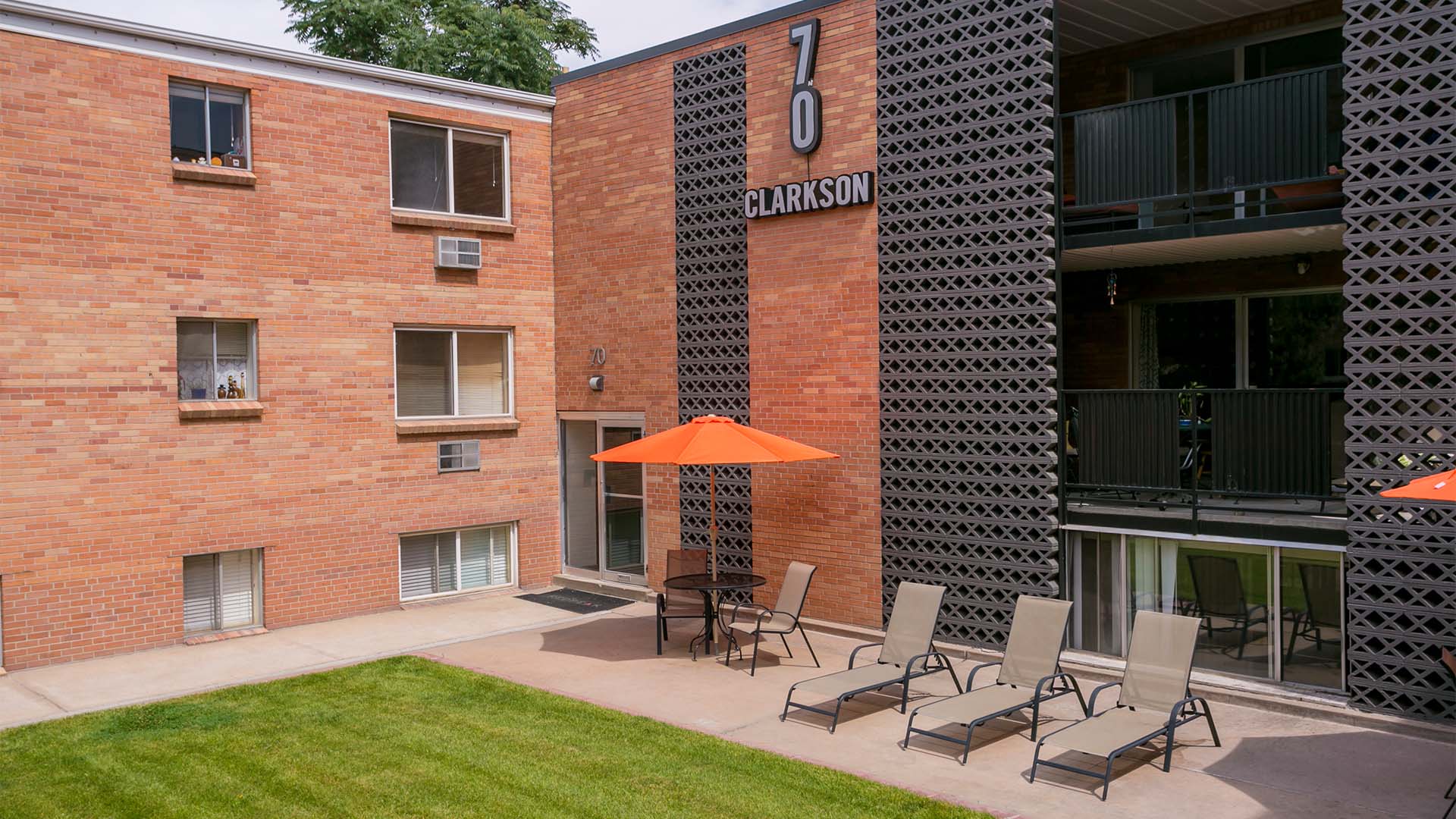 70 Clarkson apartments with classic decorative cinderblock styling and large courtyard with lawn.