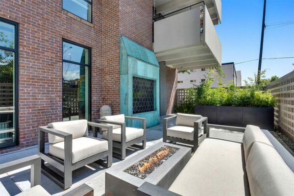 Outdoor lounge with comfortable seating and fire pit.
