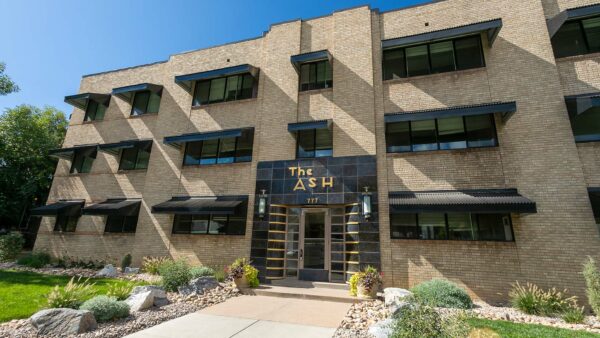 777 Ash apartment building with blonde brick construction and art deco style entrance.