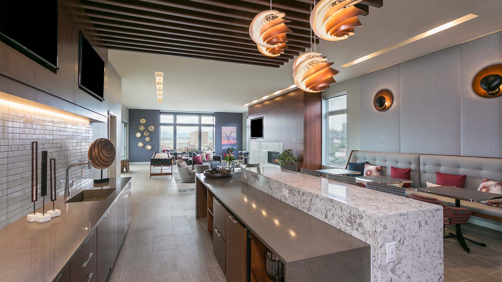 Lounge with comfortable seating, games area, community kitchen, and modern furniture and artwork.