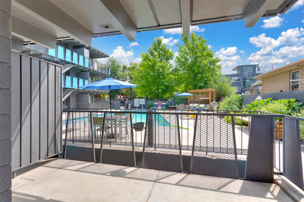 Balcony with metal railing overlooking pool area.