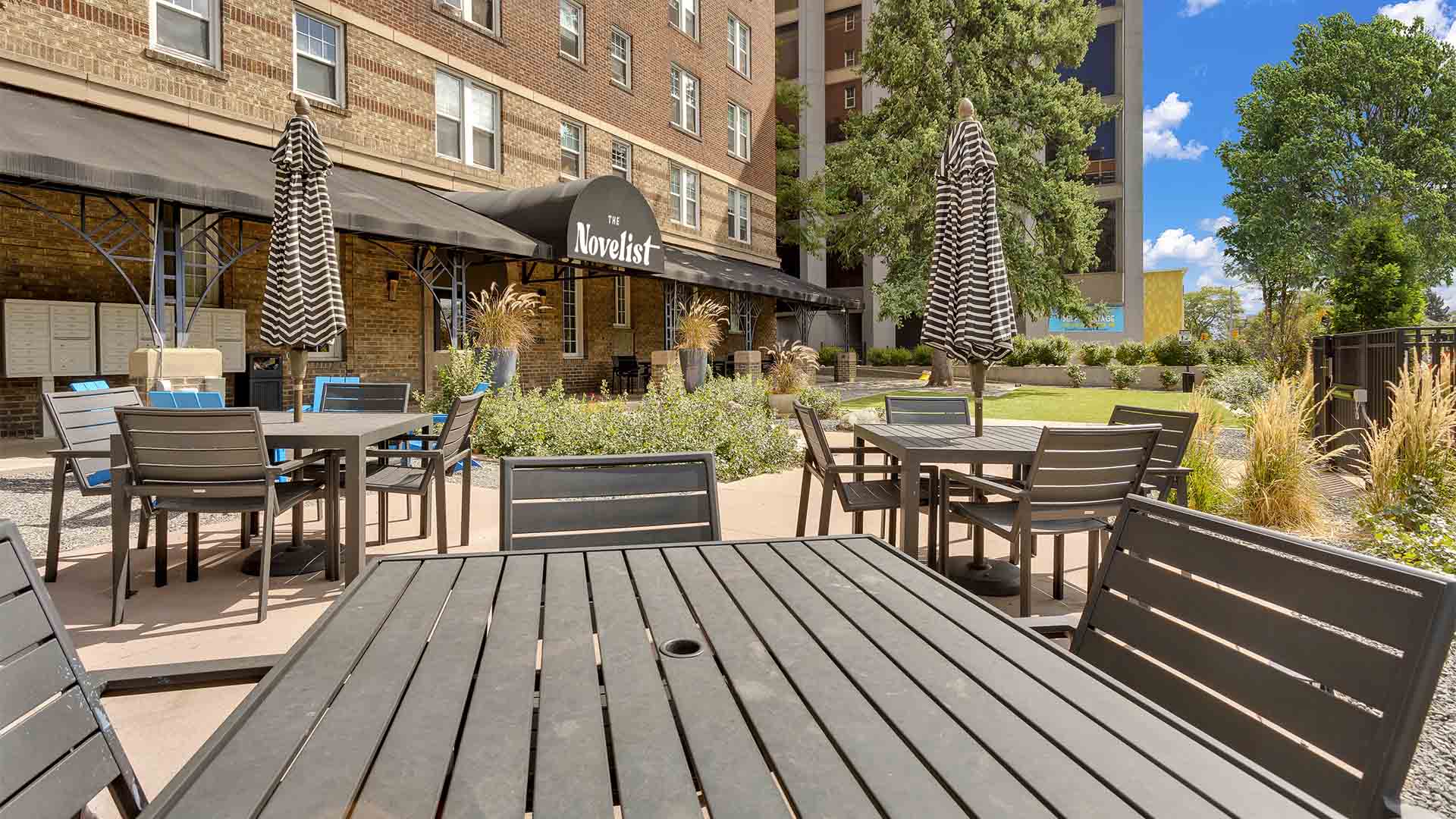 Outdoor courtyard with lush landscaping and dining tables.