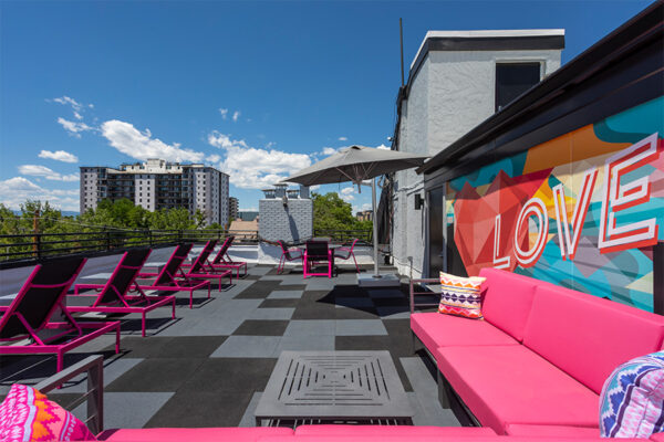 Rooftop patio with outdoor couches and mural art.
