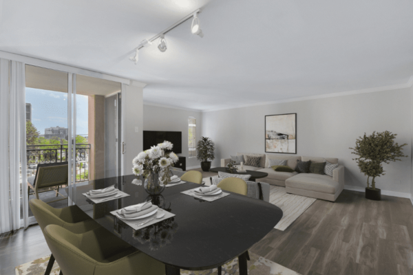 living room with dining area, view of couch and tv, and entry to the balcony