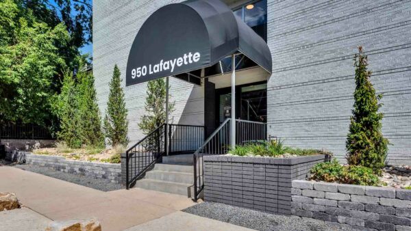 Entrance to 950 Lafayette Apartments, with awning and lush landscaping