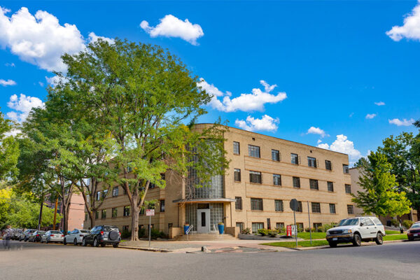 970 Penn apartments with classic blonde brick art deco construction and tall trees.