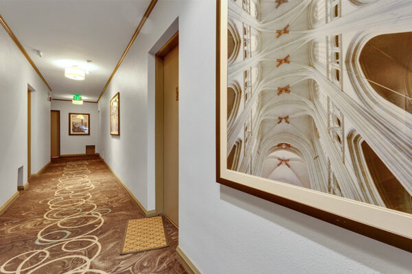 970 Penn apartment hallway with decorative carpet and architectural wall photography.