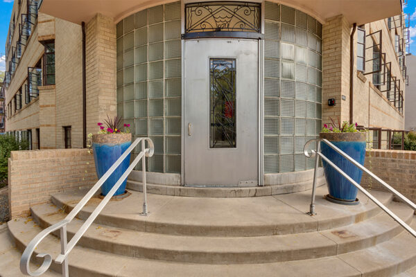 Entrance to 970 Penn with decorative metal door and round glass brick wall.