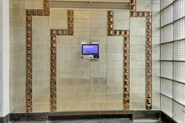 970 Penn apartment lobby with decorative metal wall tiles and digital check in screen.