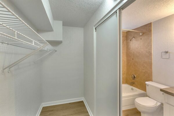 Closet with wire shelving and door to bathroom.