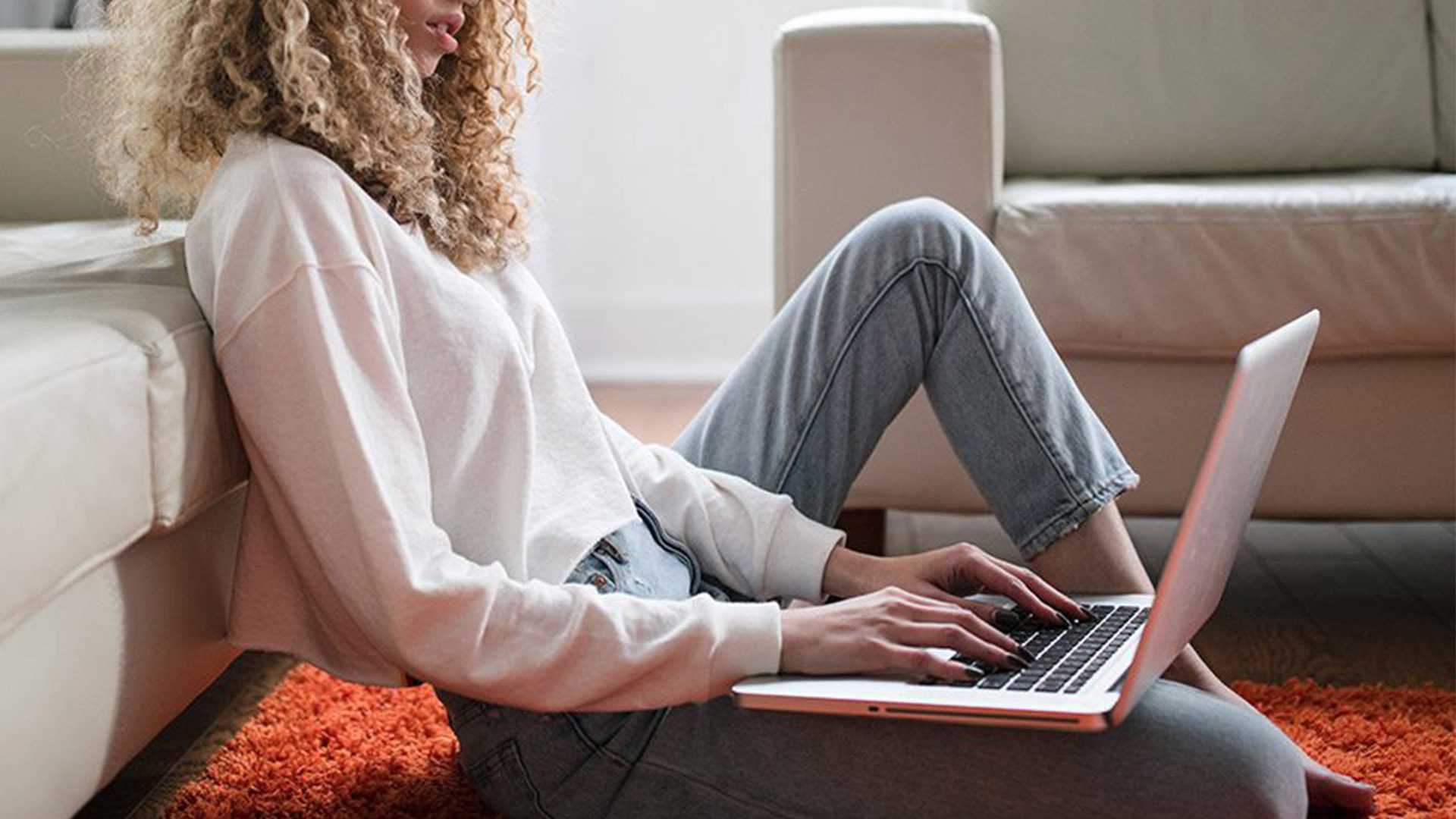 Woman on computer in apartment living room.