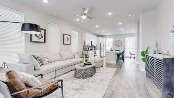 Living room with wood floor, modern furniture, plush sectional, and leather lounge chair.