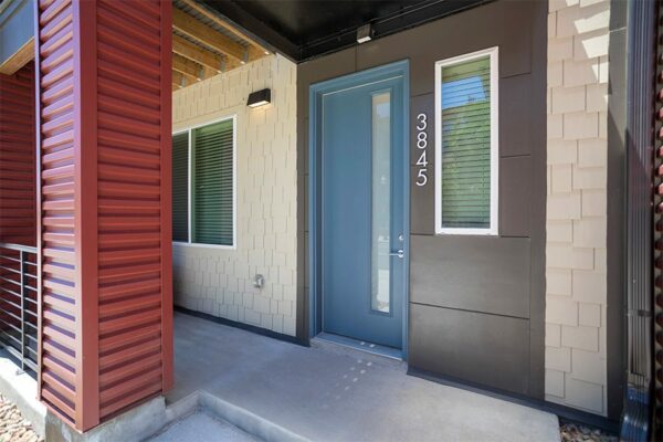 Townhome entrance with modern blue door and 3845 metal address numbers.
