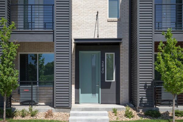 Entry to townhome with modern design and metal 3840 address numbers.