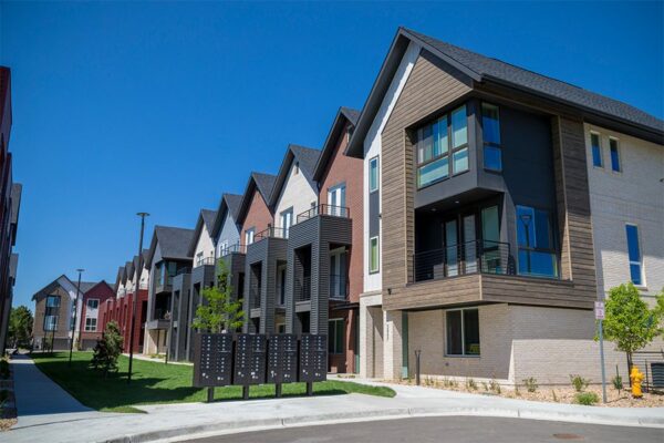 Dayton Station townhomes with balconies overlooking lush green courtyard with mailboxes.