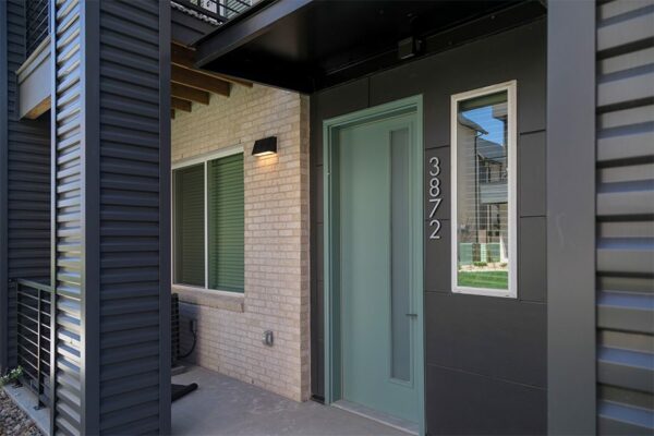 Entrance to Dayton Station townhome with modern door and 3872 metal address numbers.
