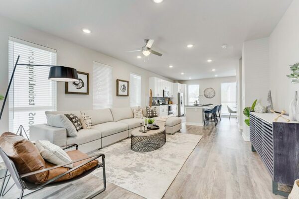 Living room with wood floor, plush sectional couch, modern furniture, and large windows.
