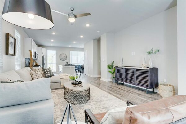 Living room with wood floor, plush sectional couch, modern furniture, and large windows.
