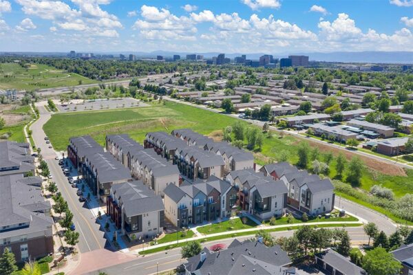 Aerial view of Dayton Station townhomes with nearby houses and distant foothills.