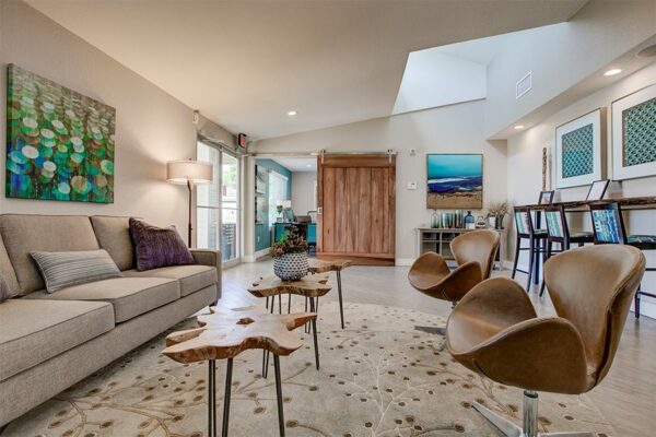 Lounge with skylight, modern furniture, and eclectic decor.