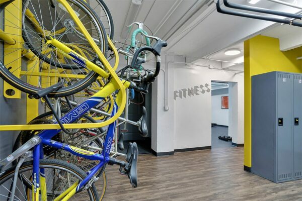 Storage room with storage lockers, bike racks on wall, and door to fitness center.