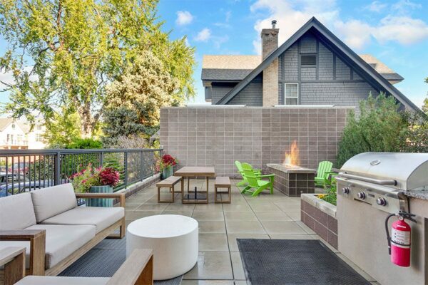 Patio with plush outdoor furniture, built in BBQ grill, and fire pit.