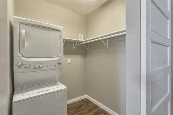 Laundry room with washer dryer and built in shelves with clothes rod.
