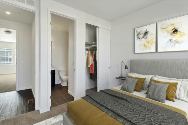 Rendering of a bedroom with an attached bathroom, closet, and white walls.