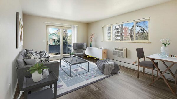 Living room with wood floor, rug, plush furniture, large window, and door to balcony.