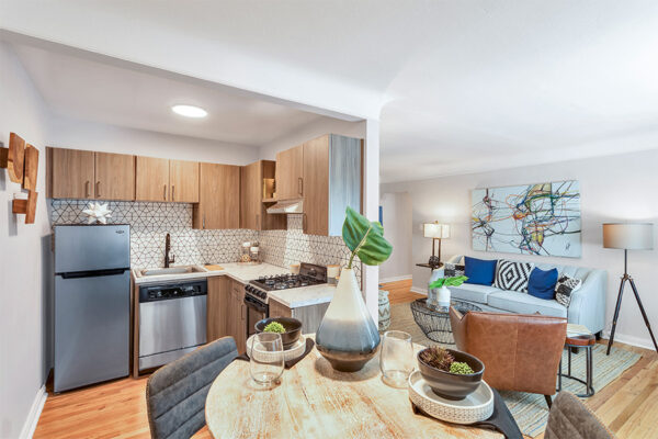 Living area with tall dining table, comfortable living room furniture, and modern kitchen.