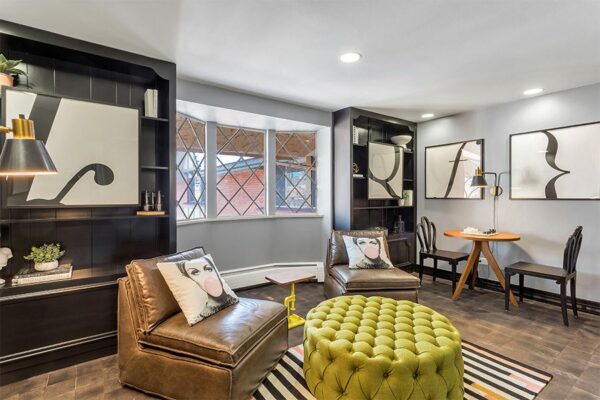 Lounge with end grain wood floor, built in shelves, modern furniture, and eclectic decor.