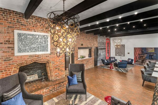 Lounge with brick accent walls, comfortable seating, fireplace, and eclectic decor.