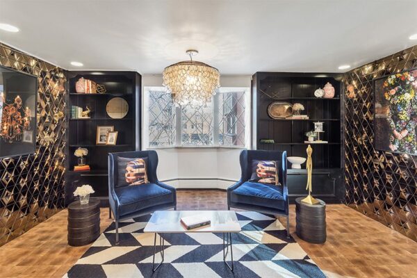 Lounge with end grain wood floor, built in shelves, geometric metal accent wall, and eclectic decor.