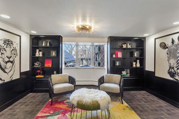 Lounge with end grain wood floor, built in shelves, modern furniture, and graphic illustrations of zebra and tiger.
