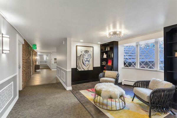 Lounge with end grain wood floor, built in shelves, modern furniture, and graphic illustration of tiger.