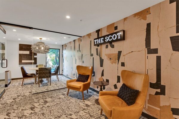 Lounge with carpet, leather wingback chairs with pillows, small room with glass walls, and The Scot lighted sign.