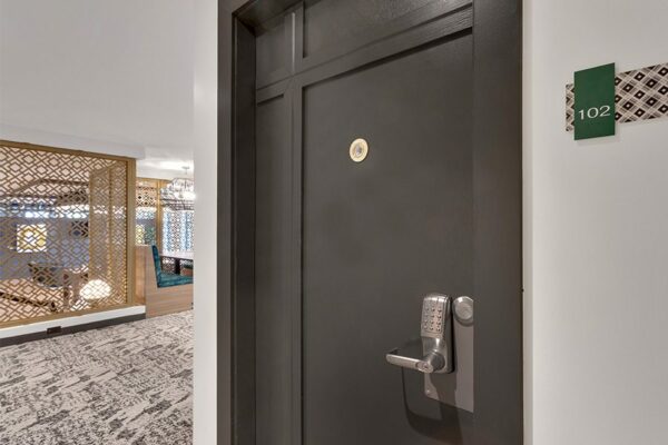 Detail of entrance to unit 102 with framed door and keypad lock.