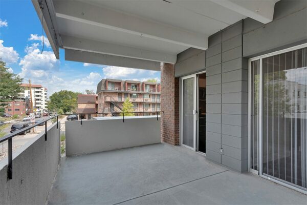 Balcony with concrete walls and doors to living room and kitchen.