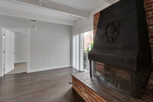 Detail of brick accent wall and fireplace with large metal hood.