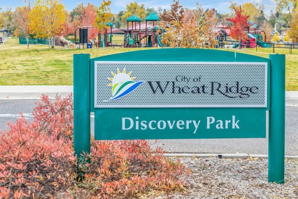 City of Wheat Ridge Discovery Park signage with autumnal bush.