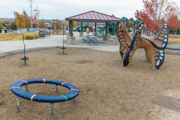 Park with gazebos, lush landscaping, and large play equipment.