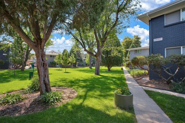 Trace Townhomes with lush lawns, mature trees, and concrete pathways.