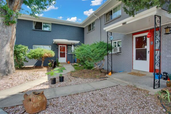 Trace Townhomes with rocky landscaping, concrete sidewalks and patios, and grey brick construction.