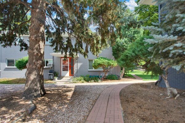 Trace Townhomes with rocky landscaping, stone paver walkways, and mature trees.