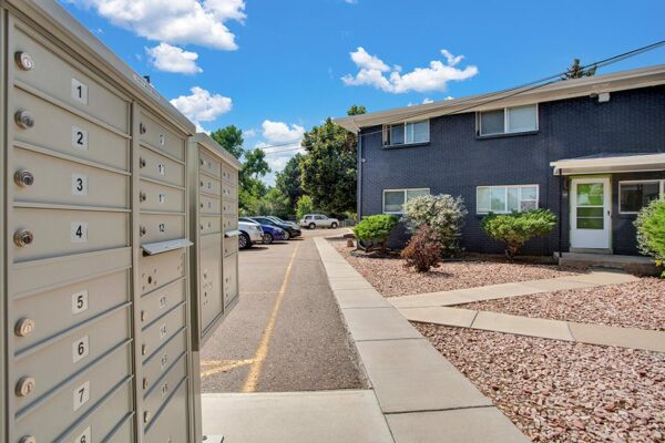Detail of Trace Townhomes mailboxes with concrete sidewalks and rocky landscaping.