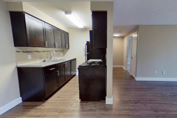 Kitchen view of one bedroom apartment looking out into living room