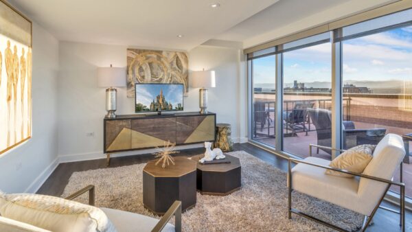 living room with couches, tv, and large windows with view of city