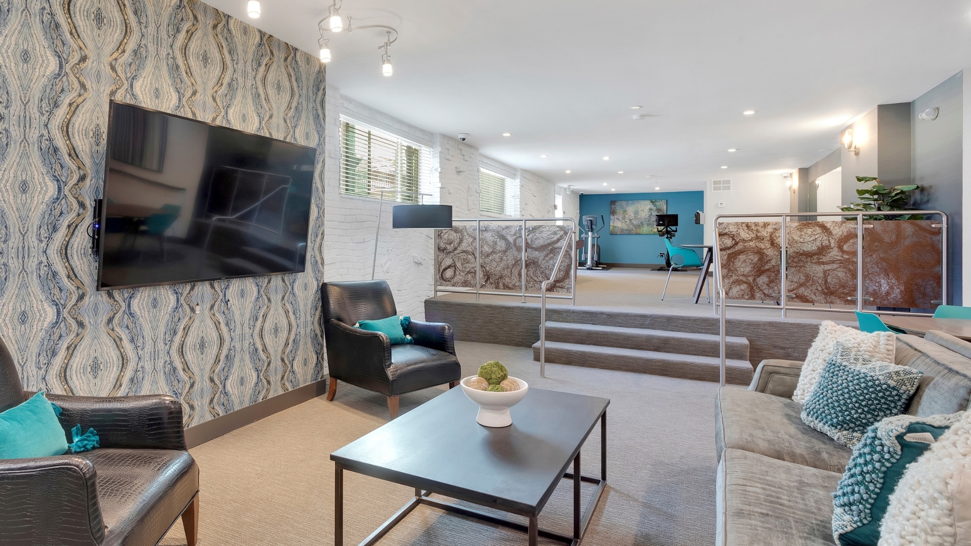 resident club room with couches, shuffle board and exercise equipment