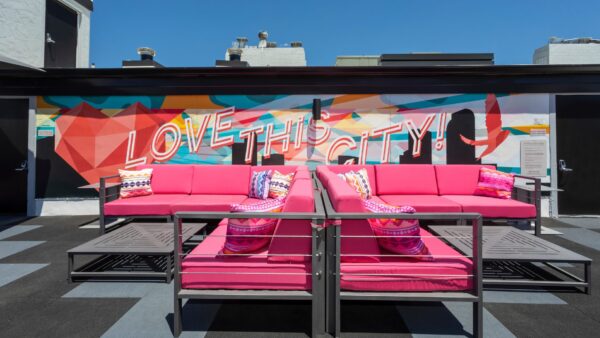 rooftop deck with pink couches and painted wall